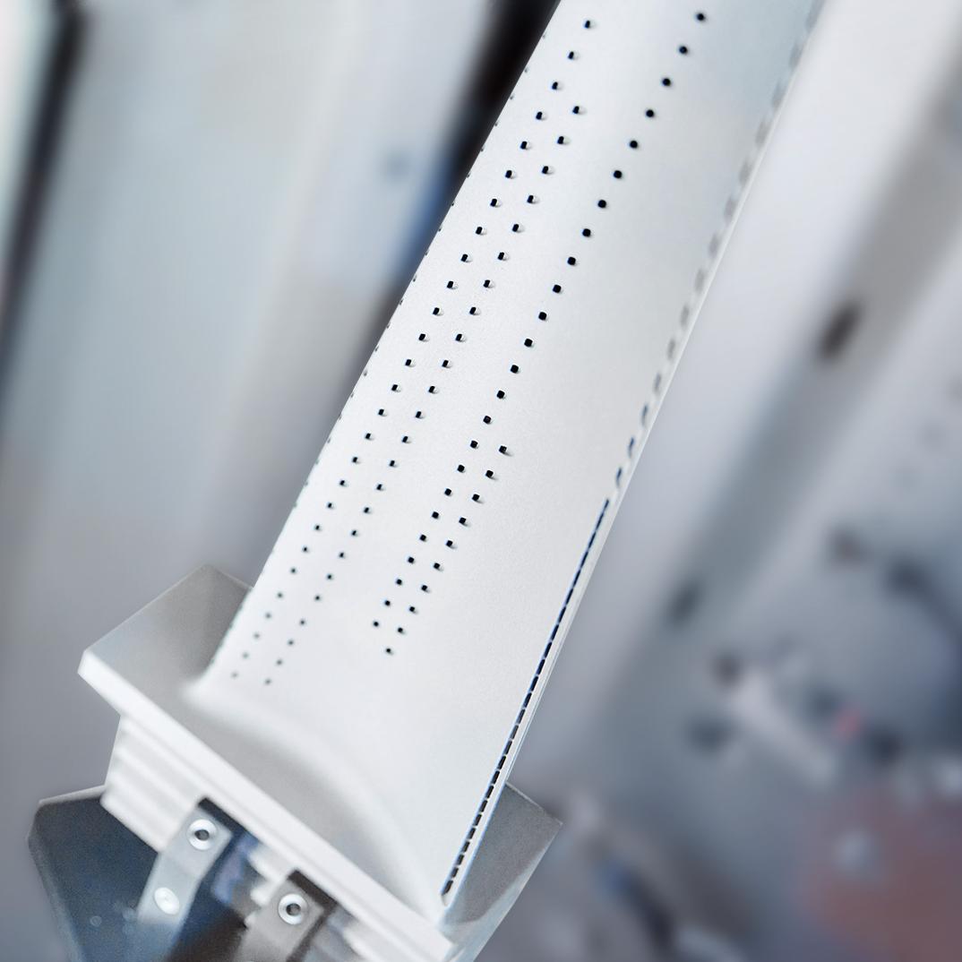 L'image montre des trous de refroidissement dans la pale, essentiels pour la protection du flux d'air, rouverts avec précision pendant le processus de finition.
