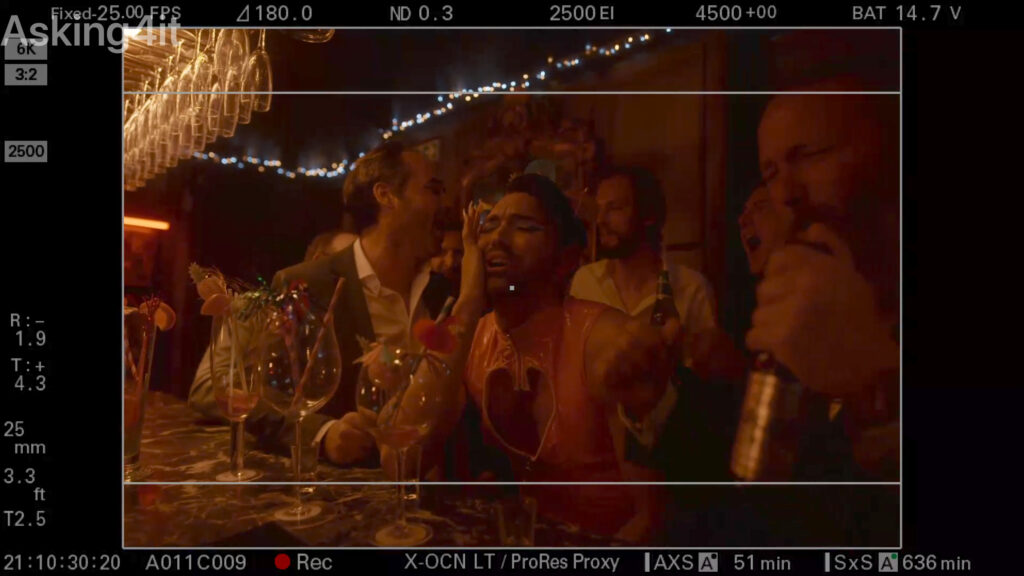 A behind-the-scenes camera monitor view shows a lively bar scene with people laughing, talking, and holding drinks, captured with ZEISS cinema lenses.