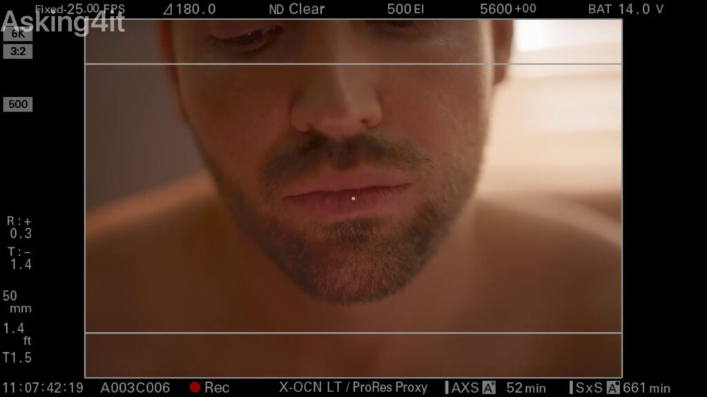Close-up image of a man's face displayed on a professional camera monitor screen, showcasing shallow depth of field and soft lighting captured with ZEISS lenses.