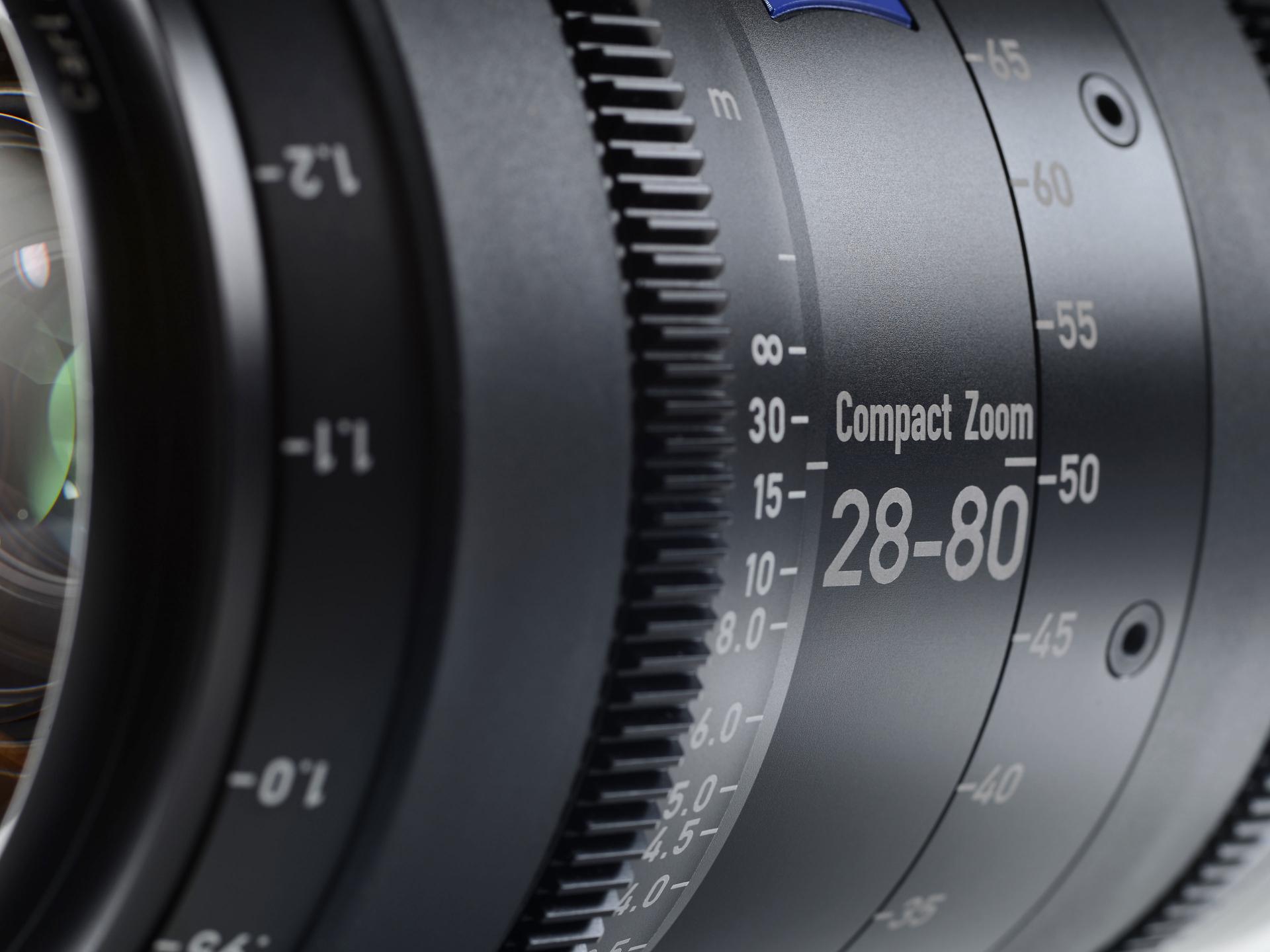 Close-up view of a ZEISS Compact Zoom 28-80mm camera lens with detailed focus and zoom markings.