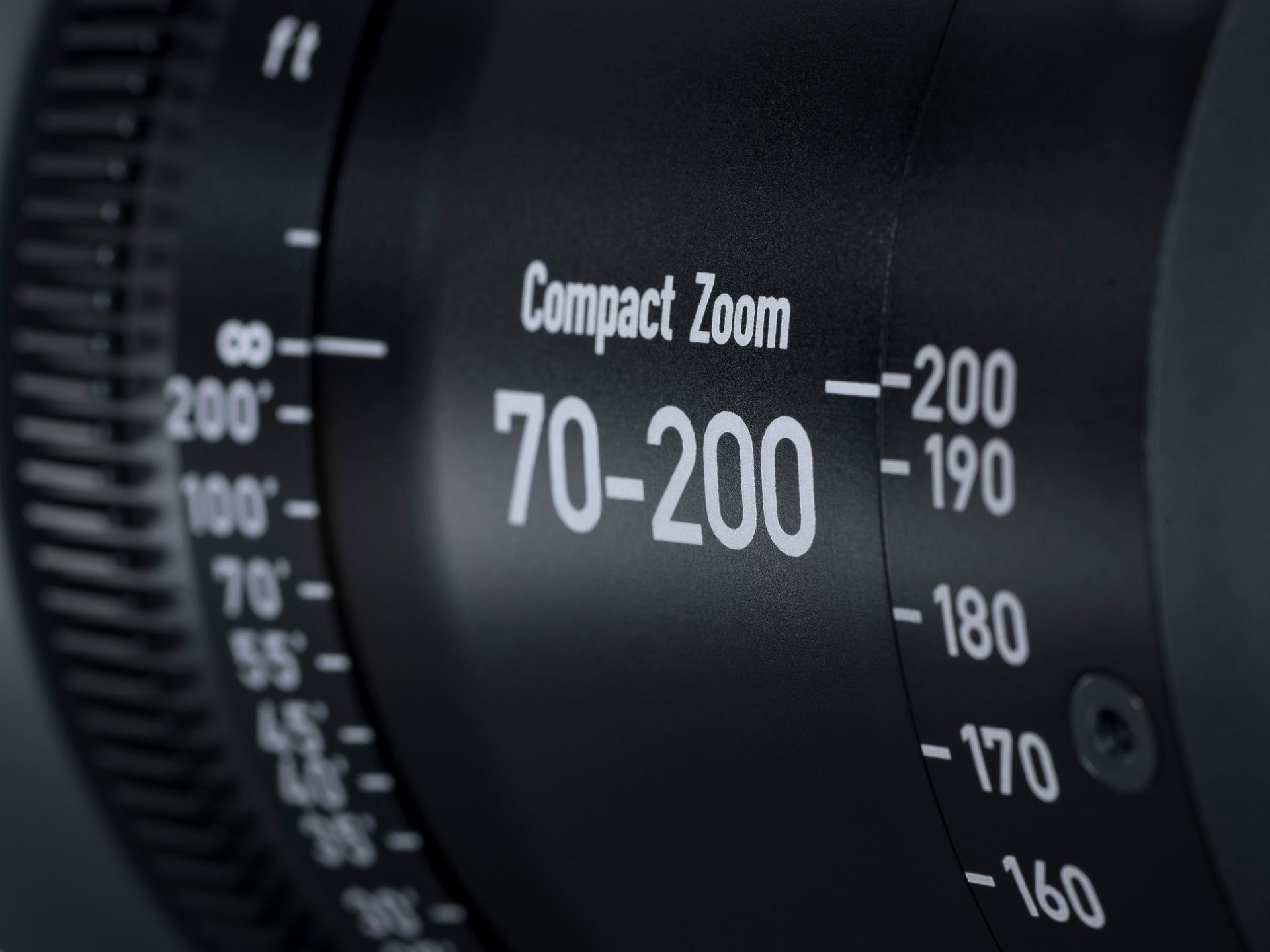 Close-up view of a ZEISS Compact Zoom 70-200mm camera lens showing focal length markings and adjustment rings.