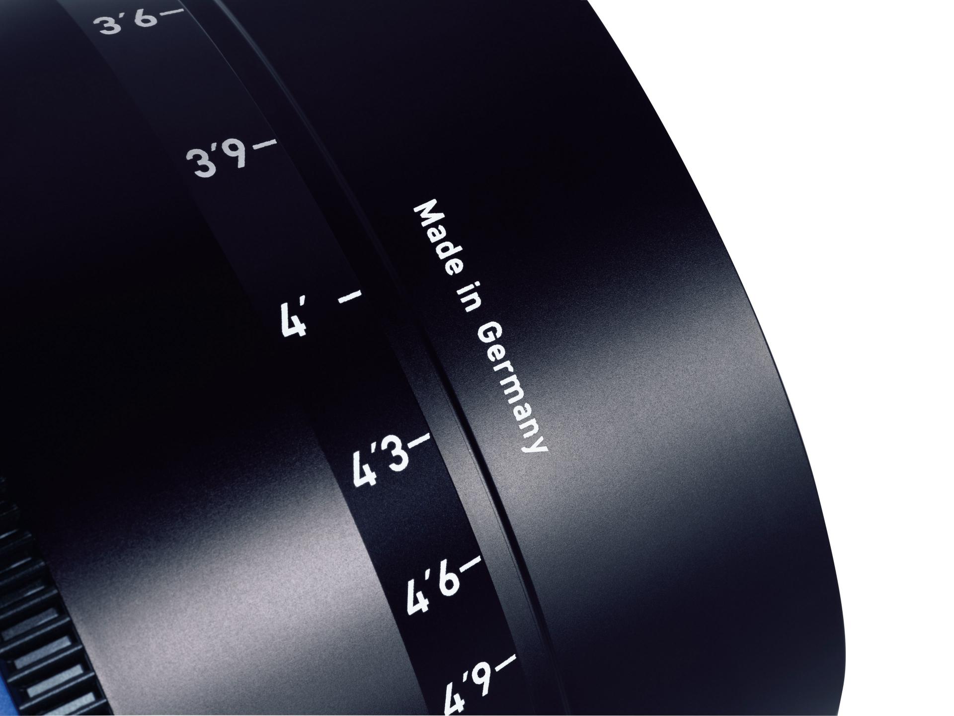 Close-up of a ZEISS camera lens showing distance markings and the text "Made in Germany" on the barrel.