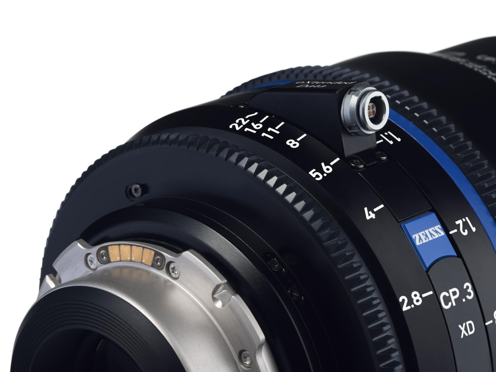 Close-up view of a ZEISS camera lens showing detailed focus and aperture markings along with the ZEISS logo.
