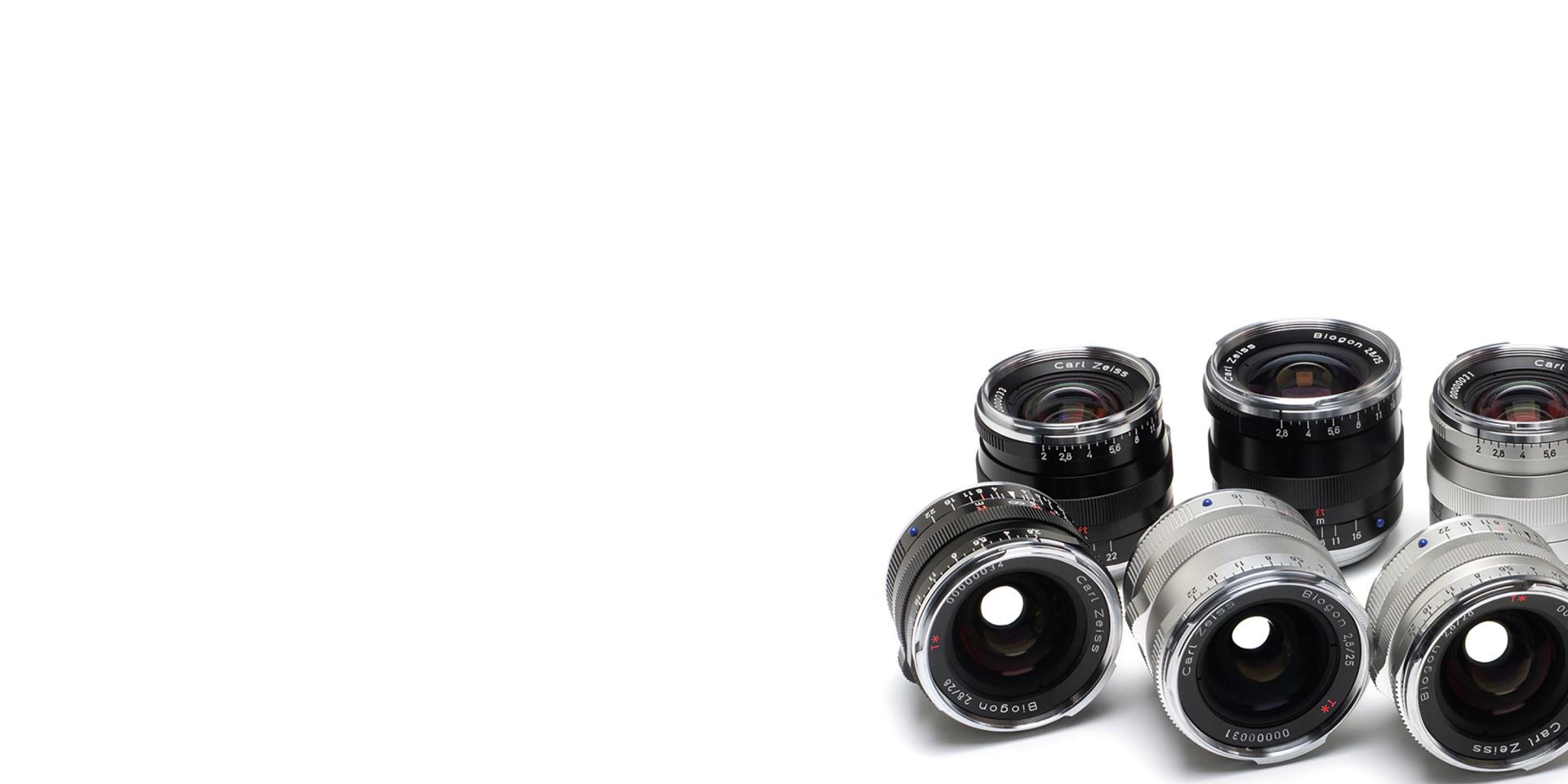 A selection of ZEISS camera lenses arranged in two rows on a white background.