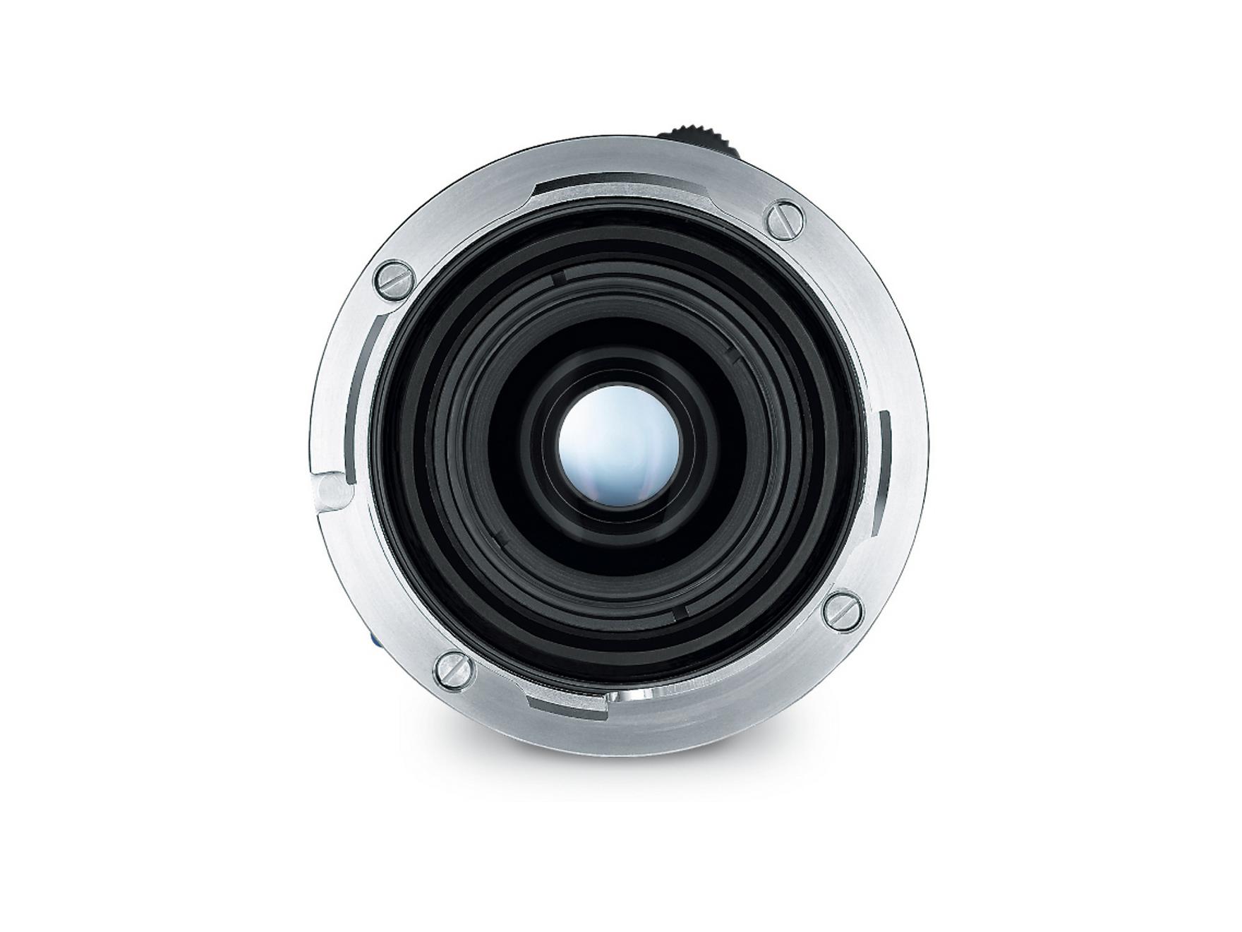 Close-up view of the rear element of a ZEISS camera lens showing its metal mount and glass optics.