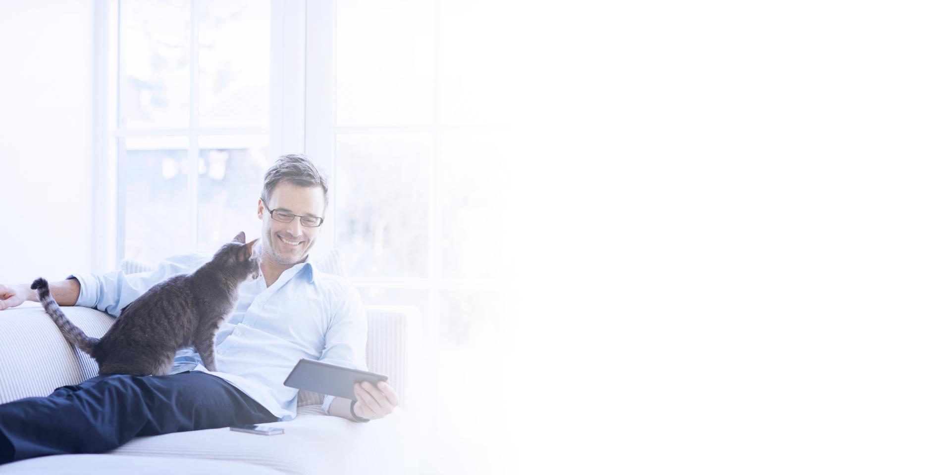 Homme utilisant une tablette tactile sur un canapé