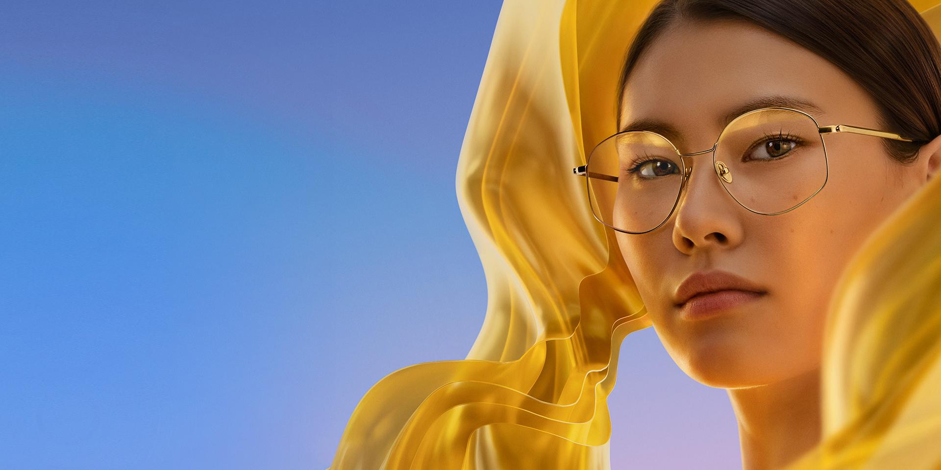 Femme portant des lunettes de vue à verres incolores munis de ZEISS DuraVision Gold UV, qui confère aux verres une irisation dorée, subtile mais bien caractéristique.