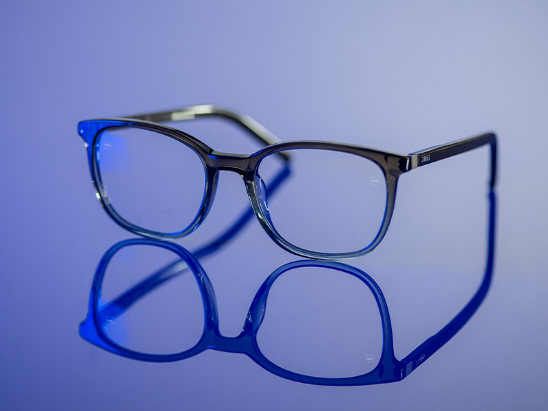 Verres de lunettes incolores sur une surface bleu brillant.