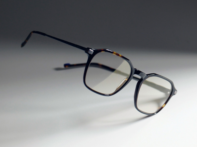 Image de verres transparents, présentant la subtile teinte dorée conférée par ZEISS DuraVision Gold UV, dans une monture marron.