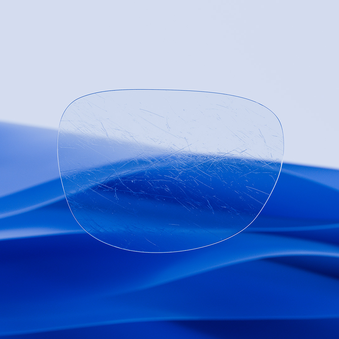 Image fractionnée d’un verre d’un côté transparent et propre, muni de ZEISS DuraVision, et de l’autre côté couvert de rayures.