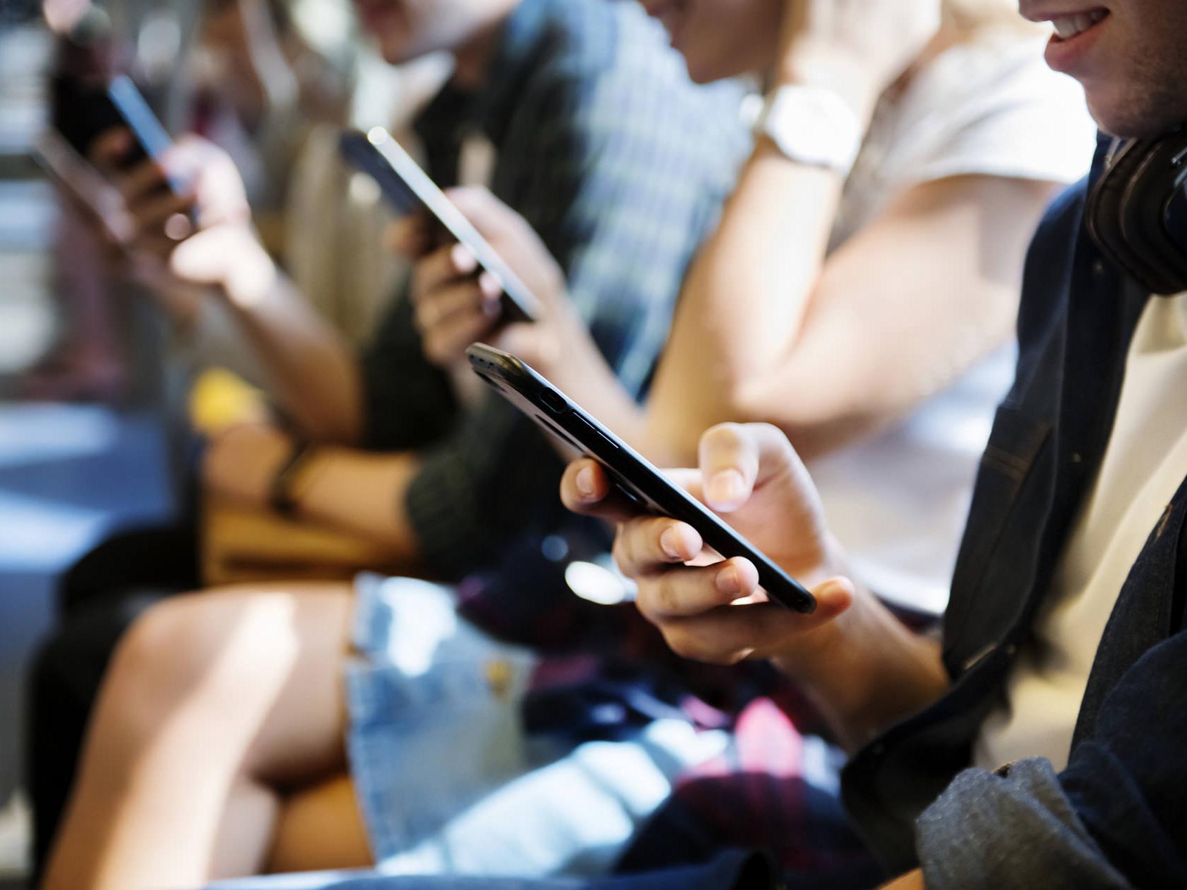 Les smartphones émettent des niveaux élevés de lumière bleue. Illustration de nombreuses personnes regardant leur smartphone. 