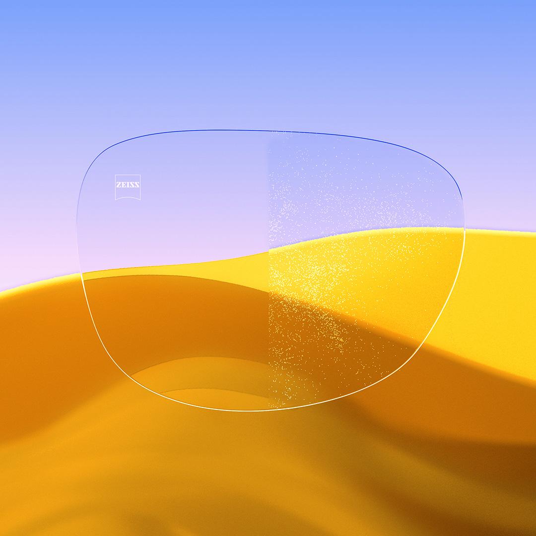 Image fractionnée d’un verre d’un côté transparent et propre, muni de ZEISS DuraVision Gold UV, et de l’autre côté couvert de poussière.