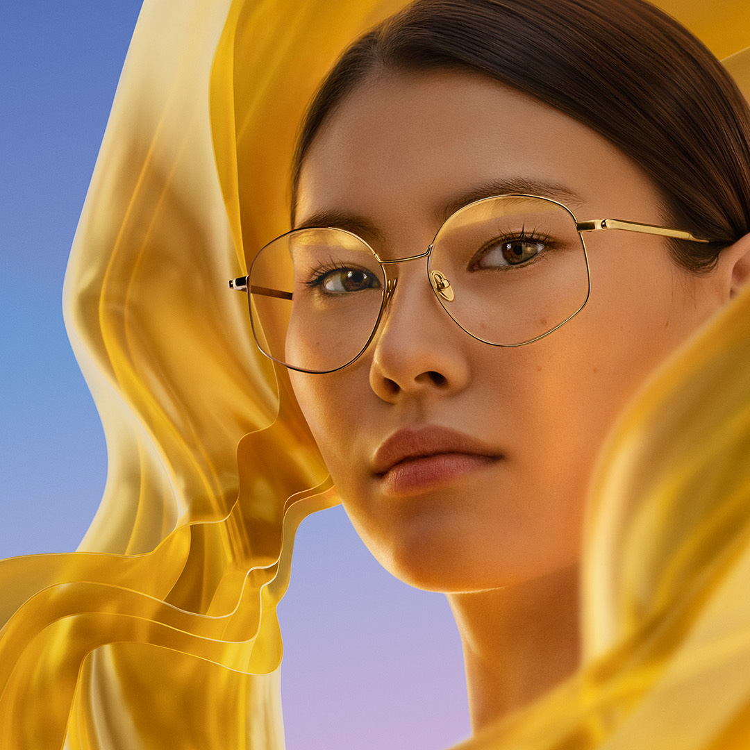 Femme portant des verres munis du traitement antireflet ZEISS DuraVision Gold UV et présentant à leur surface la subtile irisation dorée obtenue.