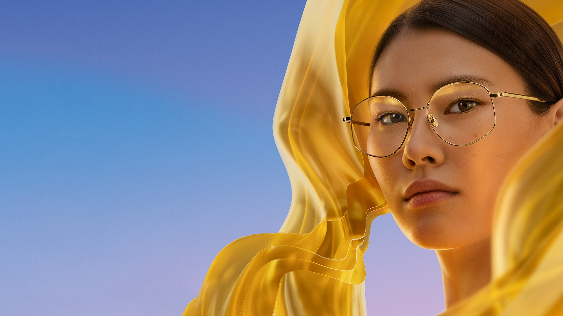 Femme portant des verres munis du traitement antireflet ZEISS DuraVision Gold UV et présentant à leur surface la subtile irisation dorée obtenue.