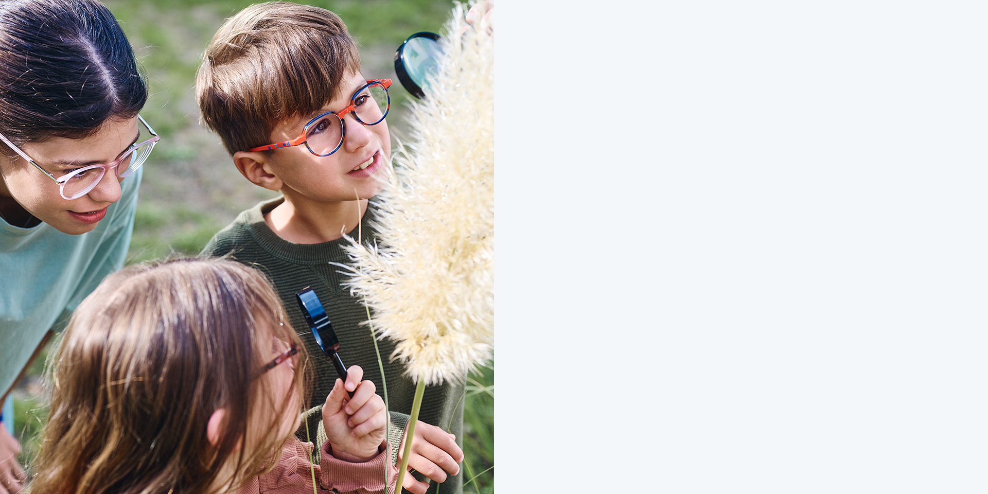 2 filles et 1 garçon qui portent des verres ZEISS MyoCare. Ils regardent une plante ; deux des trois enfants observent la plante à la loupe.