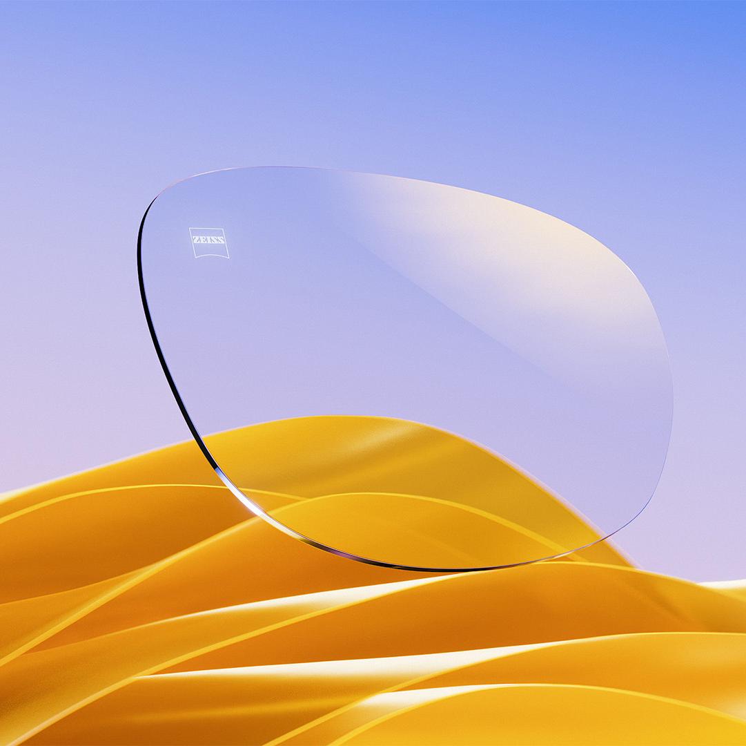 Un verre ZEISS devant un fond de tissu doré.