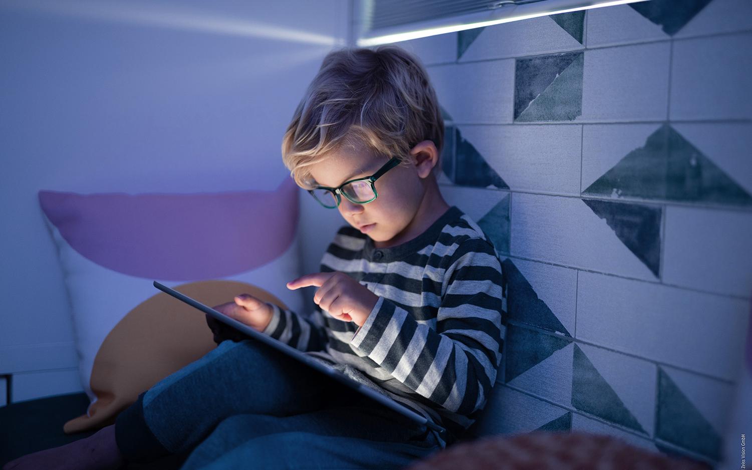 Deux petites filles charmantes et enjoués qui jouent sur une tablette électronique dans la bibliothèque scolaire. Technologie sans fil utilisée à but pédagogique et autodidacte. Les modes de vie et amitiés. Les enfant de l’âge de la maternelle