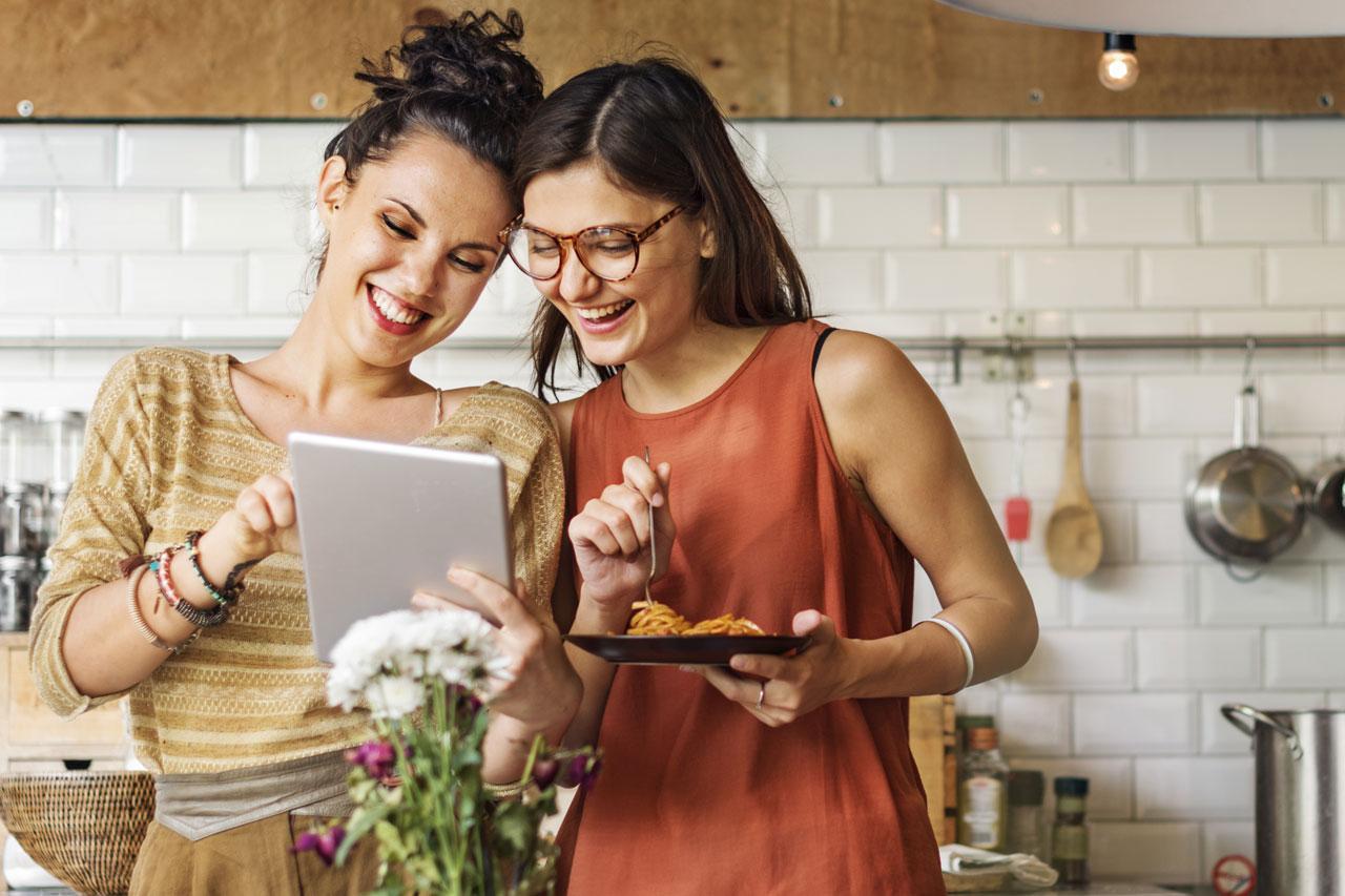 Deux amies dans une cuisine, se préparant à mettre en œuvre une recette