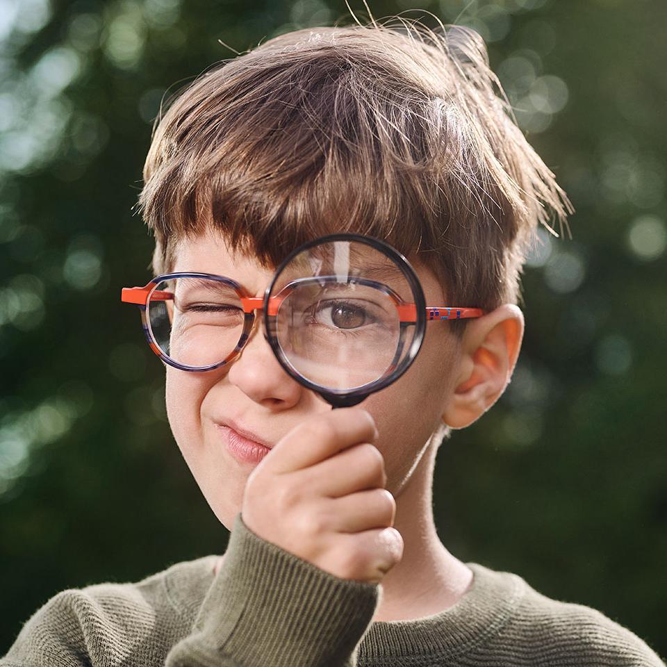 Garçon portant des lunettes utilisant une loupe 