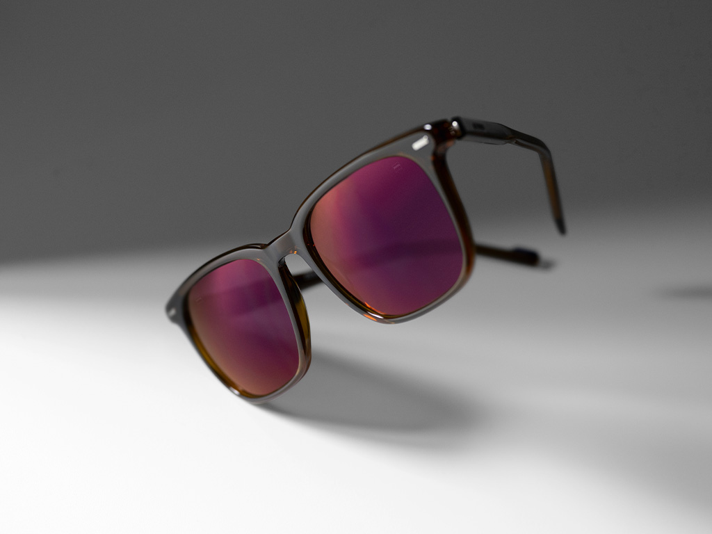 Image d'un verre de lunettes de soleil correctrices ZEISS avec des verres teintés bordeaux et un traitement de verres ZEISS DuraVision Gold.