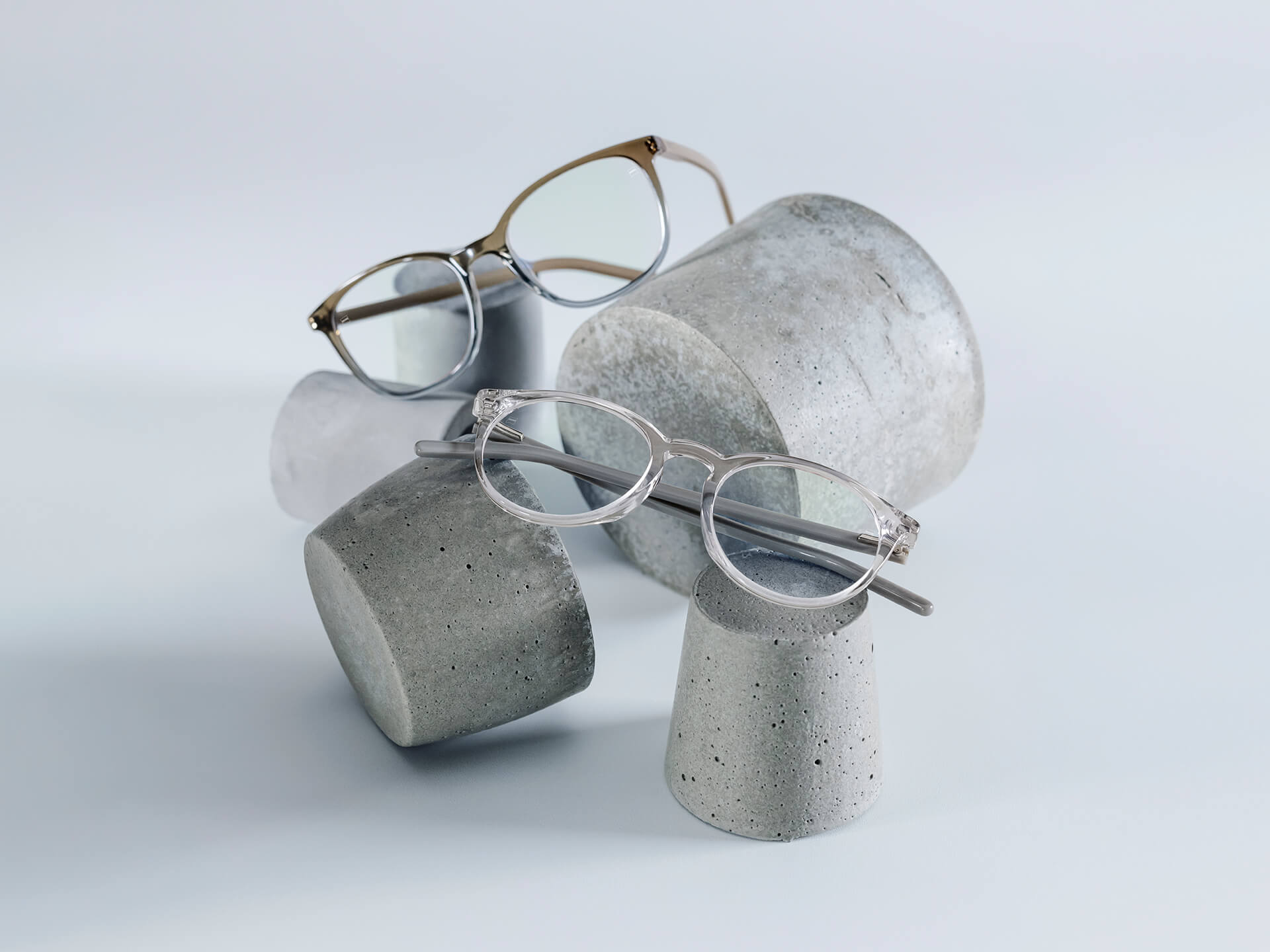 Des lunettes avec des verres ZEISS dotés du traitement DuraVision® Chrome sont placées sur des piédestaux de pierre de différentes tailles.