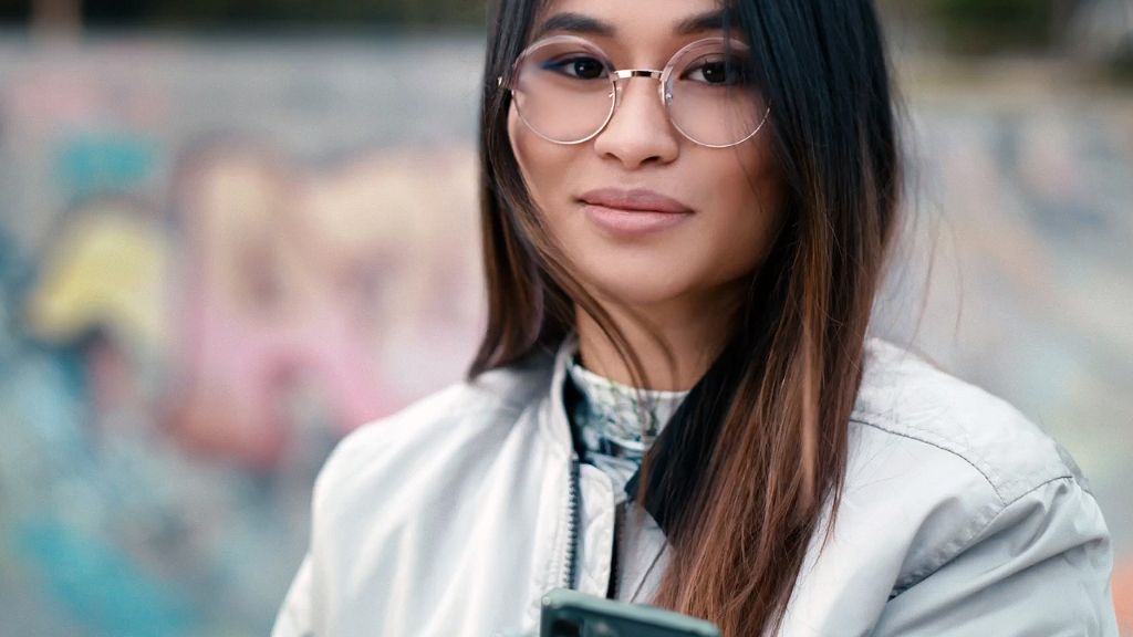 Une jeune femme dans un skatepark portant des verres Unifocaux ZEISS SmartLife.